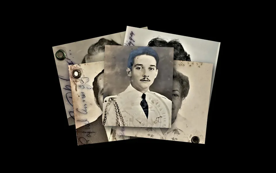 A pile of old passport photographs on a dark surface, a portrait of a young Trujillo in a white uniform on top